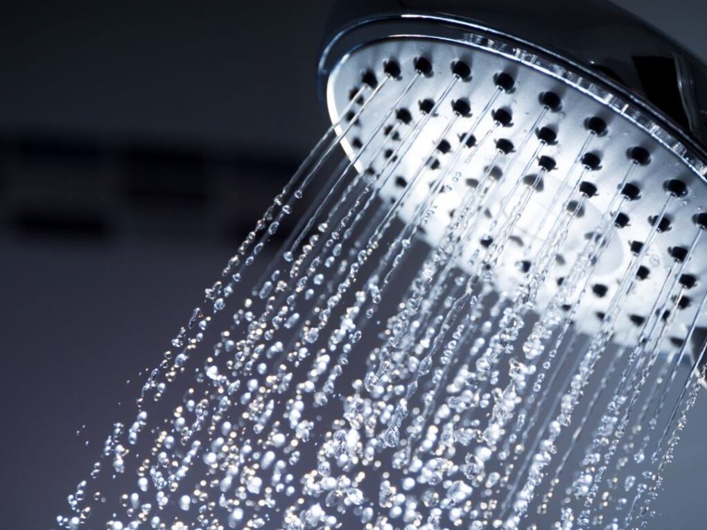 Where-Brevard-Comes-to-Play-26-1024×1024 Close-up of a showerhead with water spraying downward.