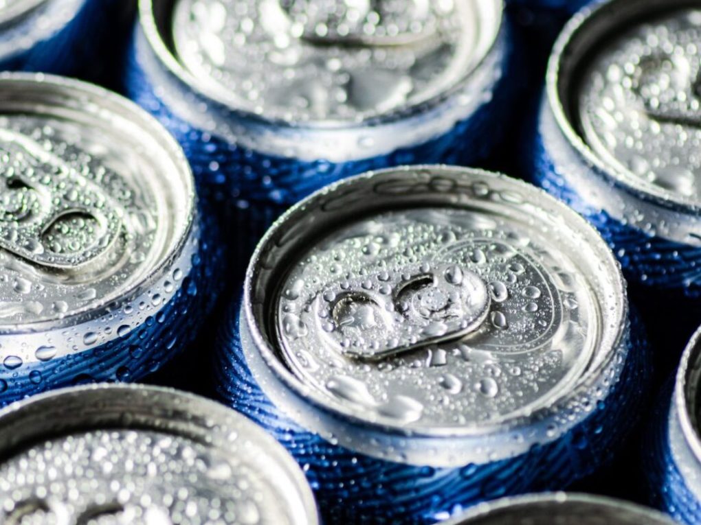 Where-Brevard-Comes-to-Play-29-1024×1024 Close-up of blue beverage cans with droplets on the lids.